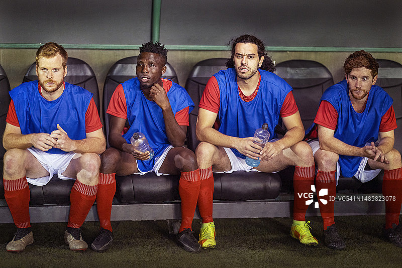 替补席上的男足球员焦急地观看比赛图片素材