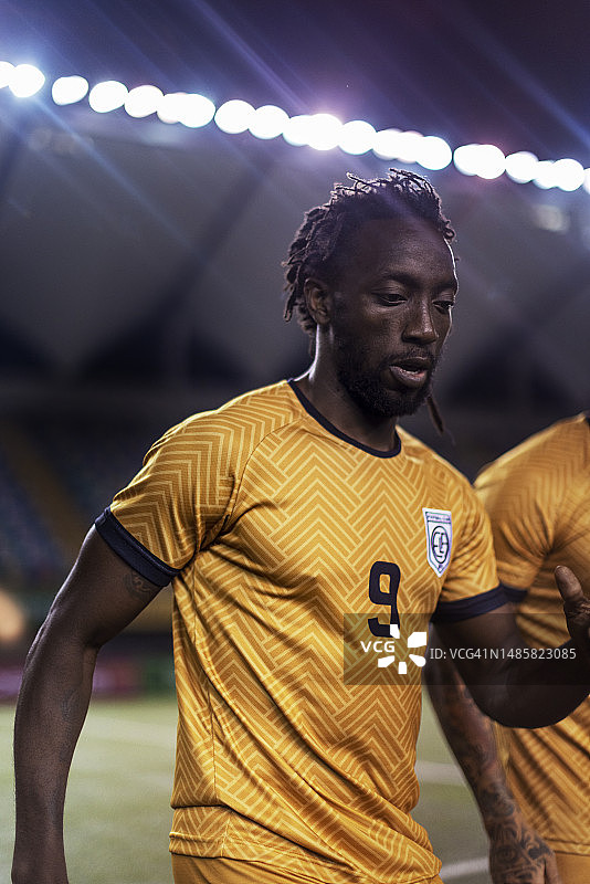 国际足球运动员在职业足球比赛中热身时显得很专注图片素材