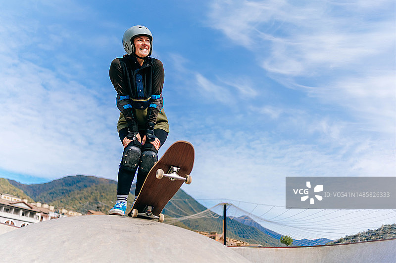 微笑的中年妇女享受滑板运动图片素材