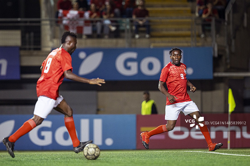 职业足球运动员准备在冠军赛中将球传给队友图片素材