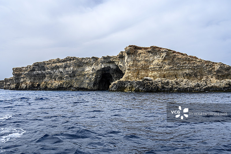 马耳他科米诺托岛上带洞穴的高耸悬崖图片素材