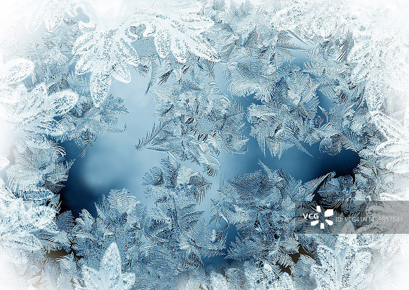 窗户上蓝白色的冰霜图案特写图片素材