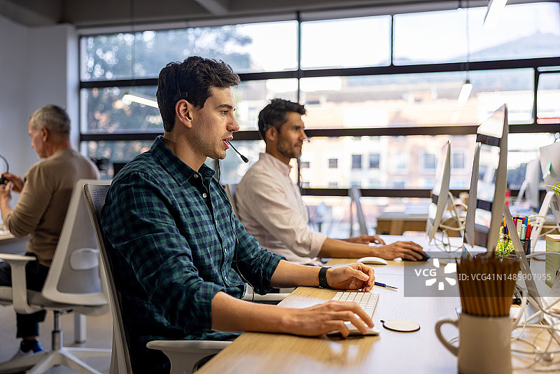 在呼叫中心担任客服代表的男人们图片素材