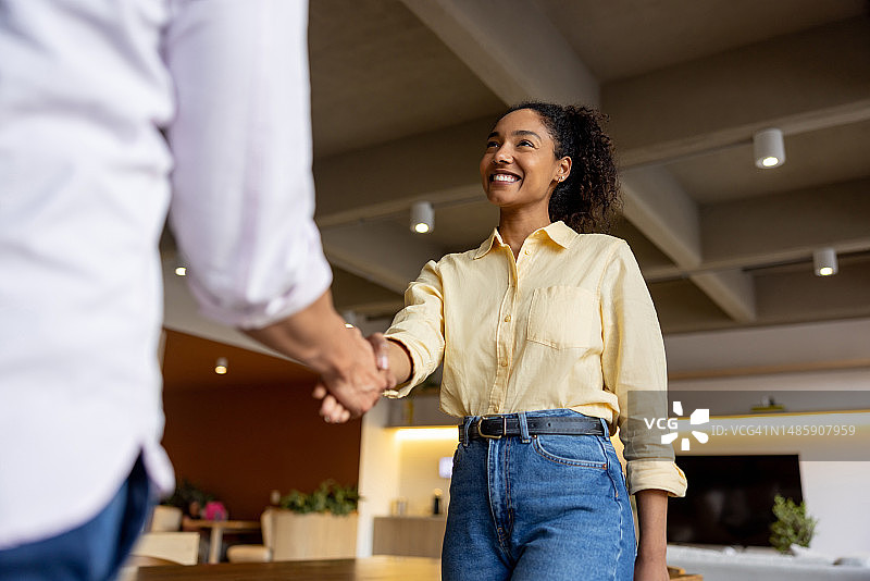 商务女人在办公室与同事握手问候图片素材