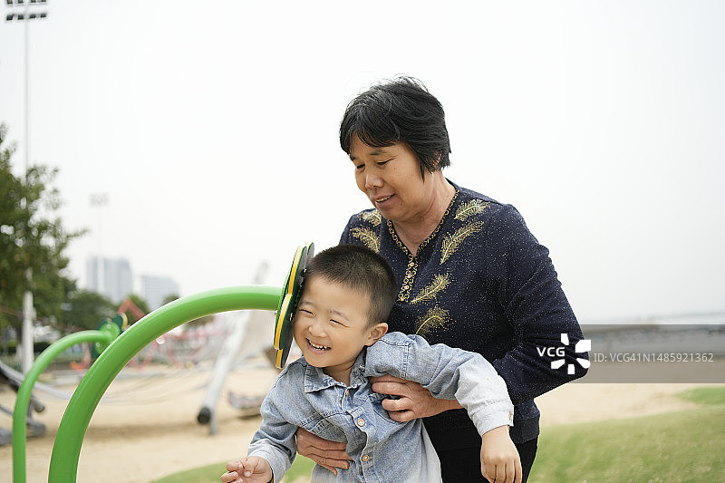 奶奶在公园里和孙子一起吹小号图片素材