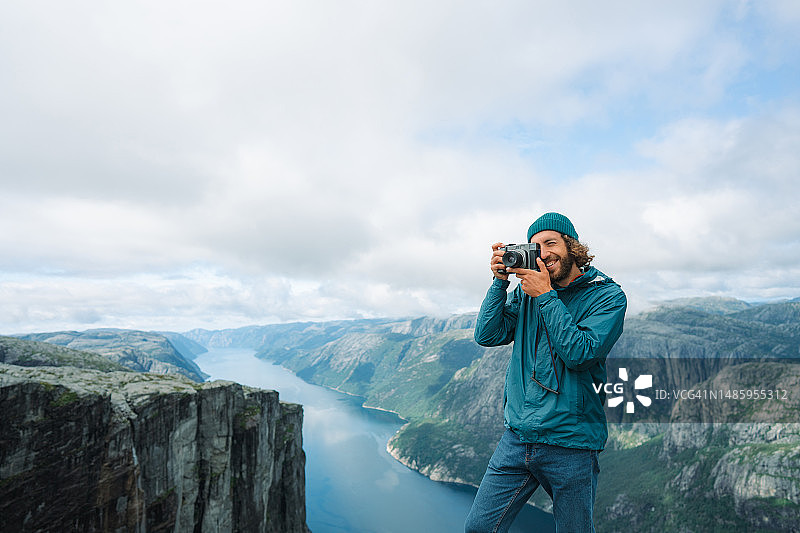 男子在谢拉格山拍摄吕瑟峡湾图片素材