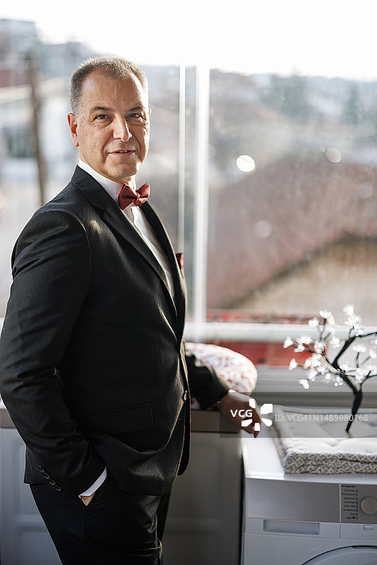 身穿西装的成熟英俊男人在家中看向镜头的肖像图片素材