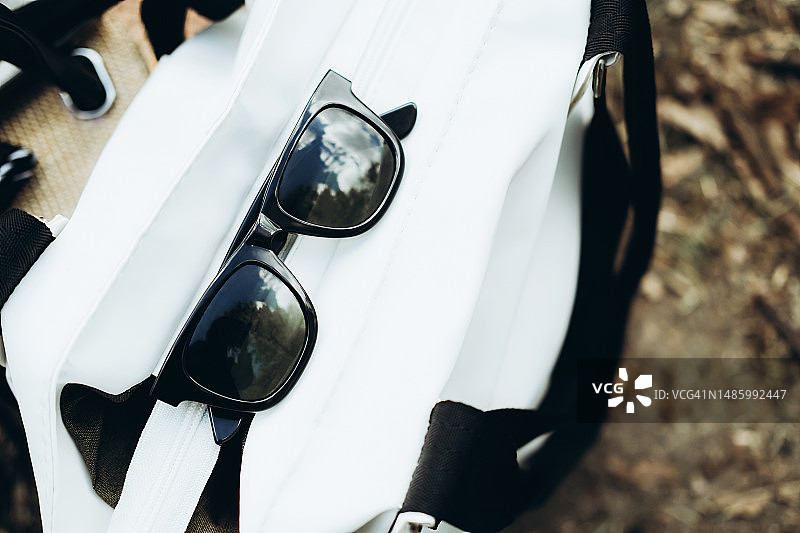 户外白色包上的黑色太阳镜图片素材
