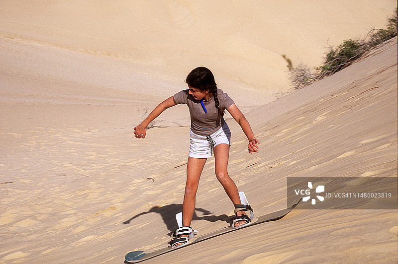 少女在莫桑比克的沙丘上玩滑水图片素材