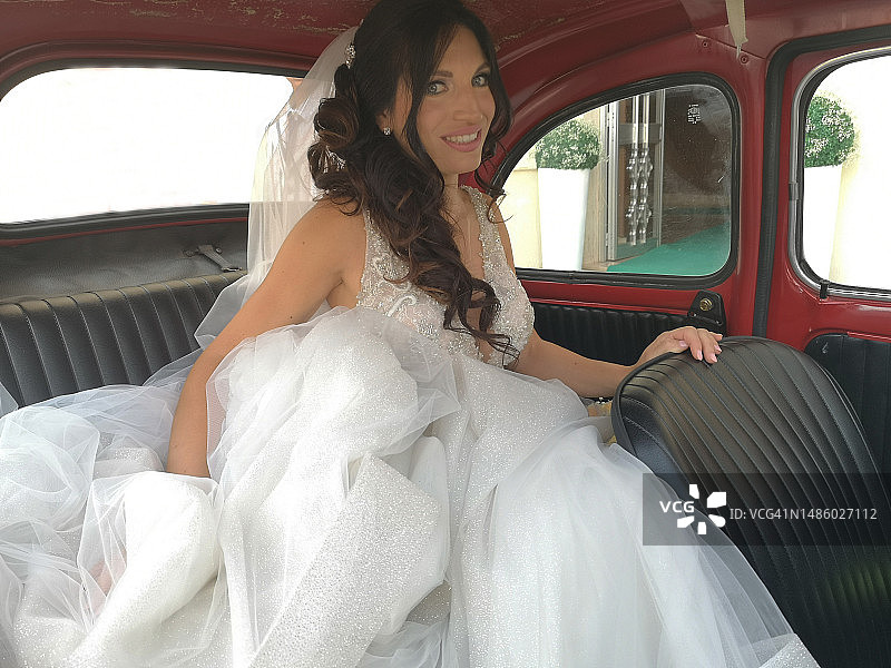 坐在老爷车里微笑的新娘肖像图片素材