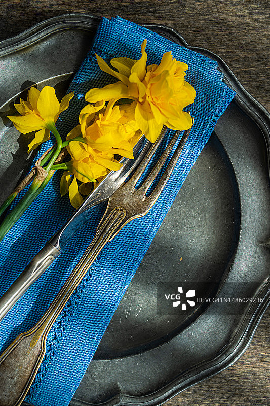 春季餐桌上的锡盘与水仙花图片素材