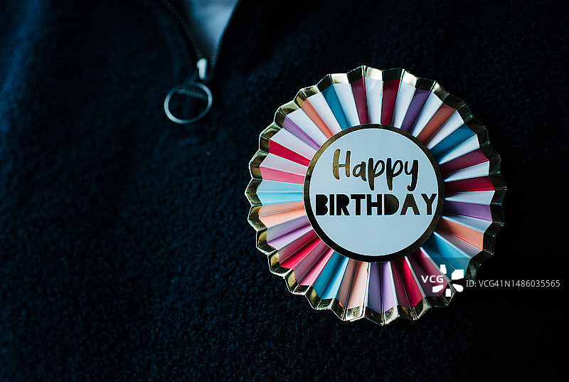 衣服上的彩色生日快乐徽章图片素材