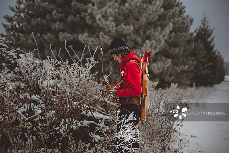 年轻猎人拿着弓、箭和箭袋的特写图片素材