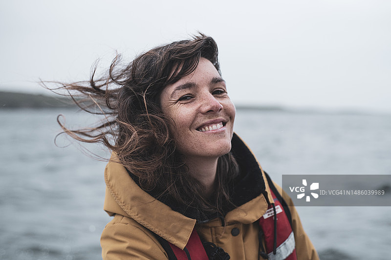 在苏格兰的船上穿着救生衣微笑的长着雀斑的女人图片素材
