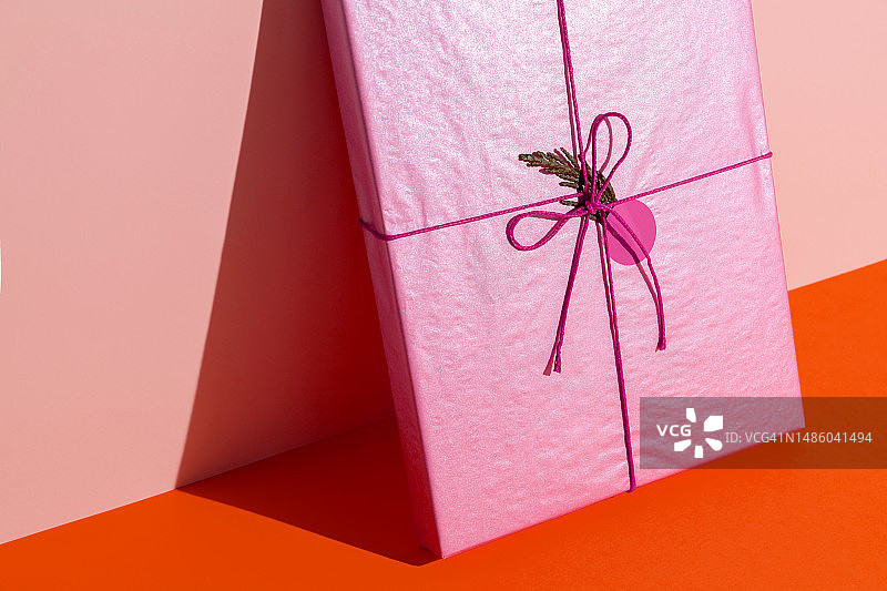 橙色背景上的粉色礼品盒（书本）图片素材