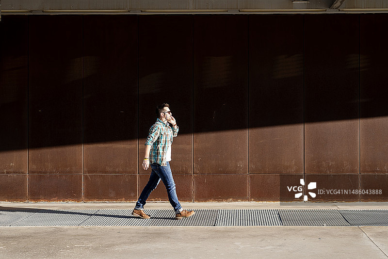 年轻男人在户外用手机交谈图片素材