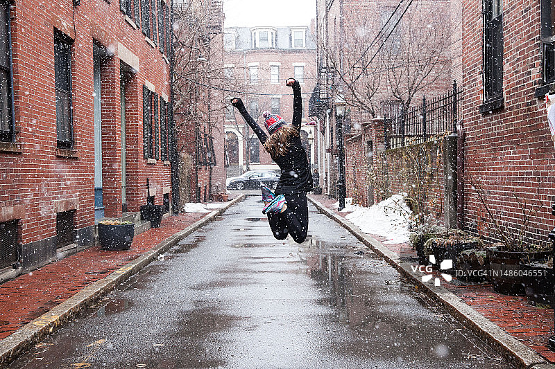 在暴风雪中跳跃的女孩图片素材