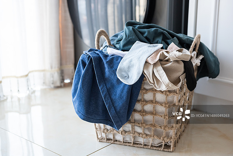 装满待洗衣物的篮子和洗衣机图片素材