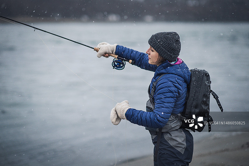 女人在暴风雪中抛竿钓鱼图片素材