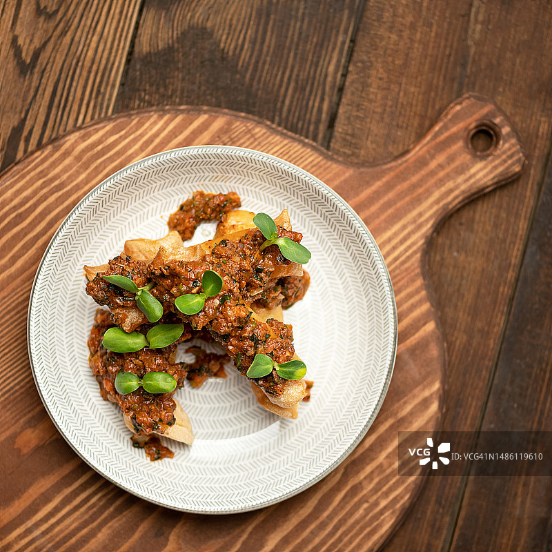 蔬菜酱汁小食配炸皮塔饼，白色餐盘俯视图，木纹背景留白图片素材
