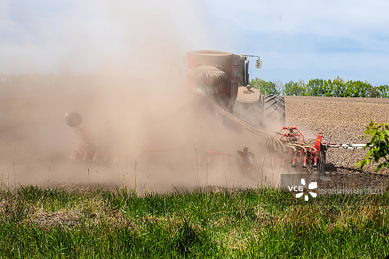拖拉机用耙子努力耕作干燥的农田图片素材