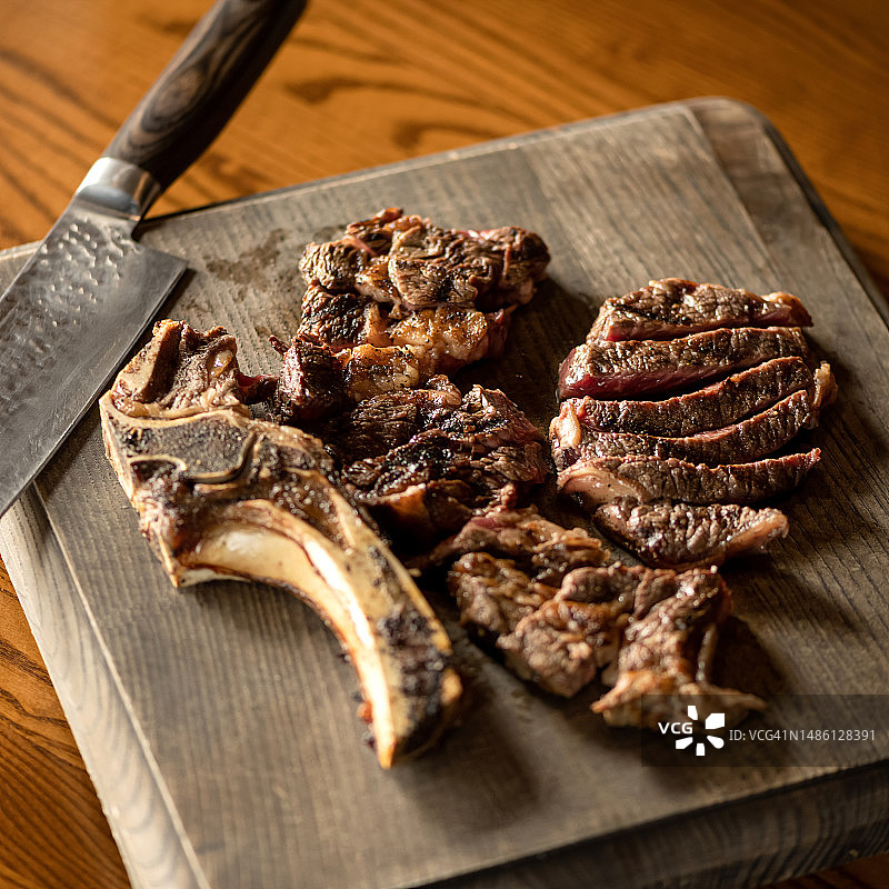 带骨斧头牛排：木板上的烤牛排图片素材