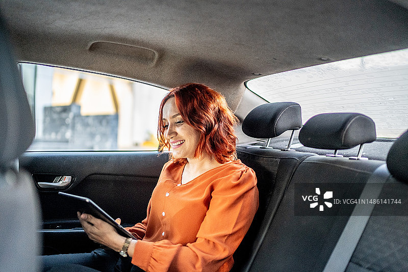 中年妇女在车内使用平板电脑图片素材