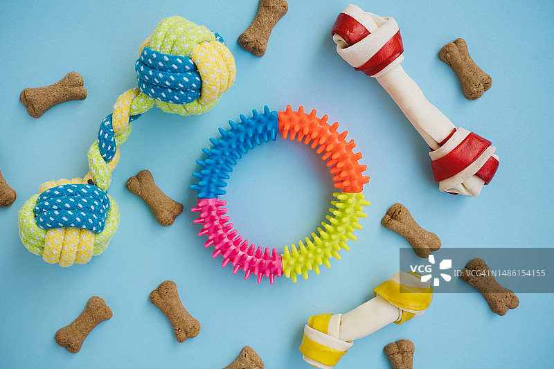 狗狗玩具：蓝色背景上的骨头零食，宠物食品概念图片素材