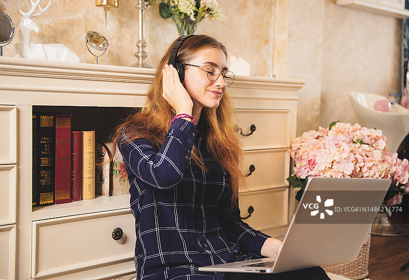 年轻女人戴着无线耳机听音乐图片素材