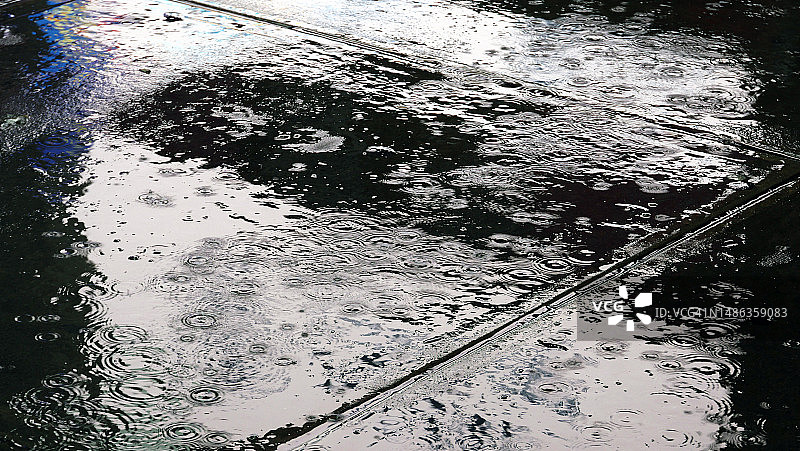 美国纽约曼哈顿时代广场，广告屏幕的白光倒映在被雨水淋湿的人行道上图片素材