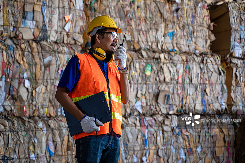 在废品回收厂工作的男性工人，废品处理厂，技术流程。图片素材