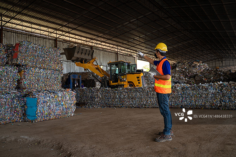 员工在废物管理设施中检查塑料废物图片素材