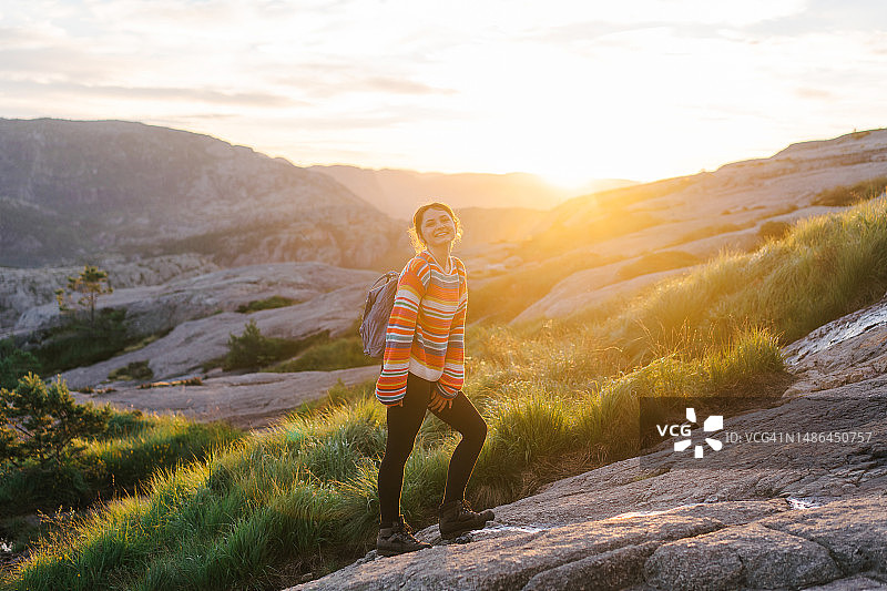 日出时分在挪威徒步前往圣坛岩的女人图片素材