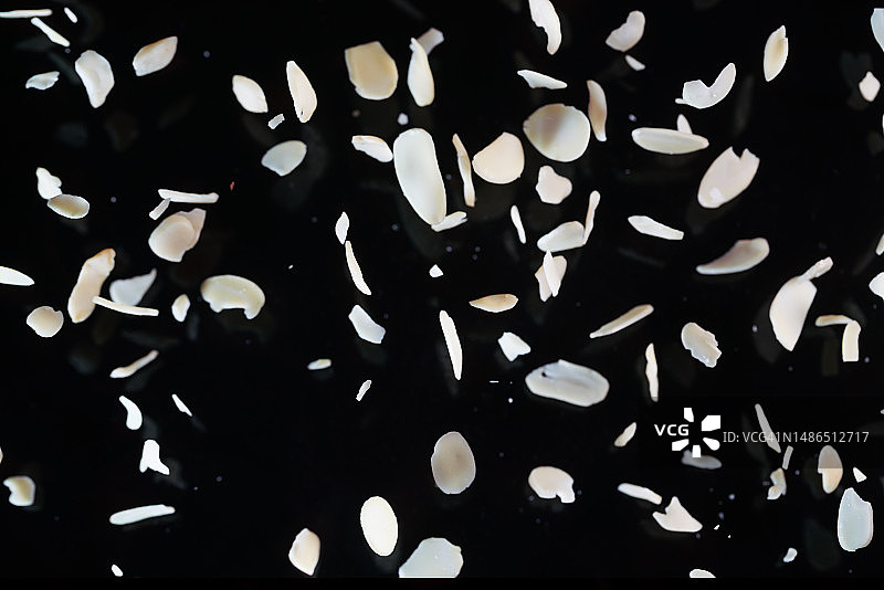 黑色背景中飞舞的杏仁片图片素材