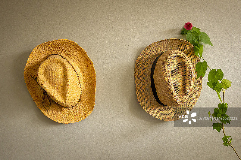 挂在墙上的两顶草帽图片素材