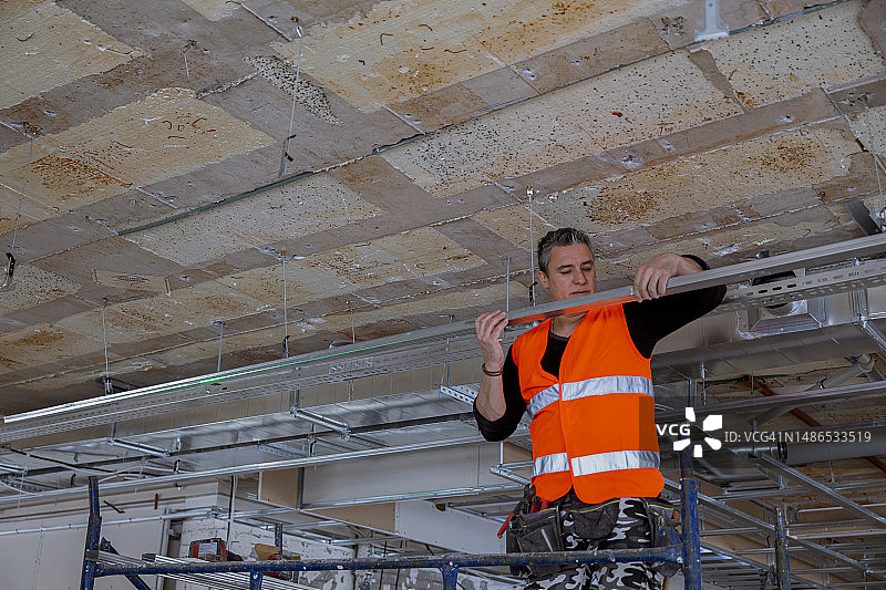 组装吊顶金属框架的建筑工人图片素材
