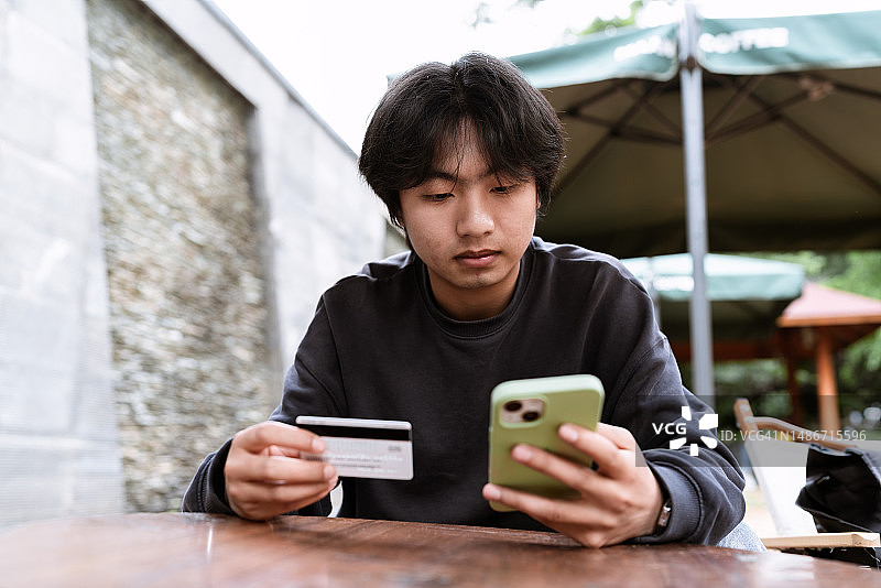 年轻男人使用信用卡在线购物图片素材