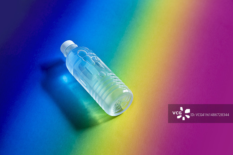 彩虹背景上的塑料水瓶俯视图图片素材