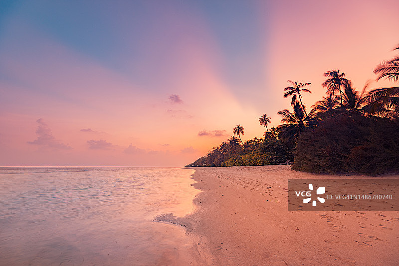 橙色日出日落阳光下的平静海浪，热带海滩风光图片素材