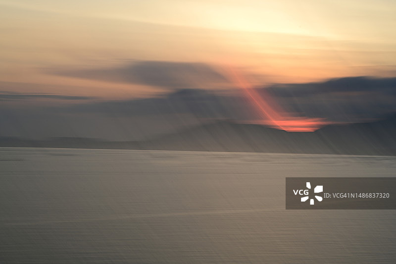 海面山脉日落与模糊光晕图片素材