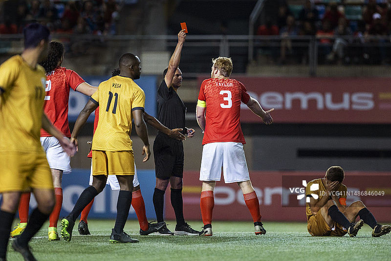 国际比赛中，裁判向与受伤球员争执的球员出示红牌图片素材