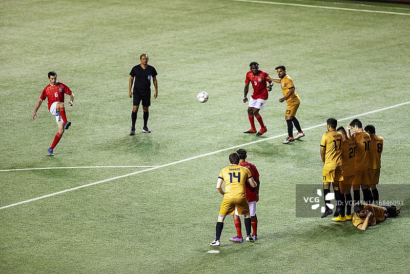 国际比赛中，专业足球运动员踢球突破对方人墙图片素材