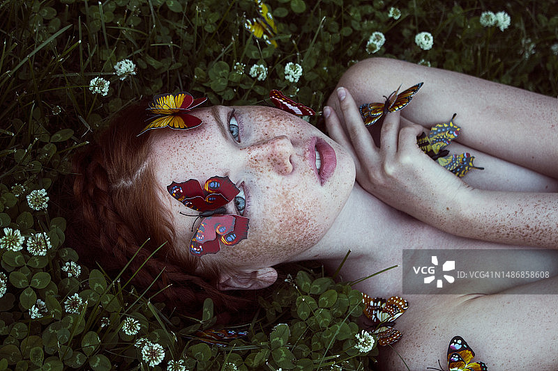 脸上涂着彩绘躺在田野上的女人图片素材