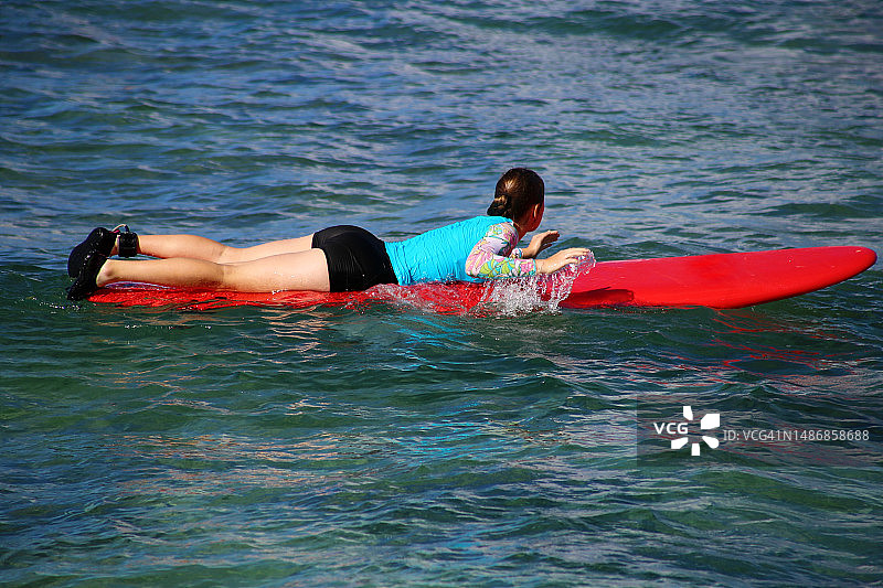 在海中冲浪的女孩，美国夏威夷考艾岛图片素材