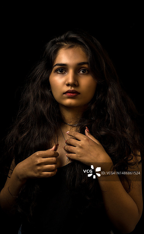 在黑色背景下的年轻女子肖像，印度古吉拉特邦瓦多达拉图片素材