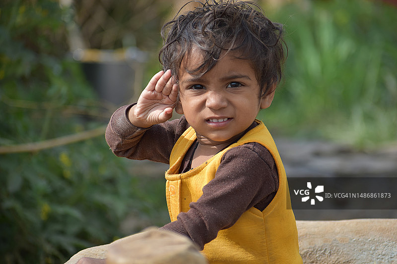 在印度北方邦班达户外做手势的可爱男孩肖像图片素材