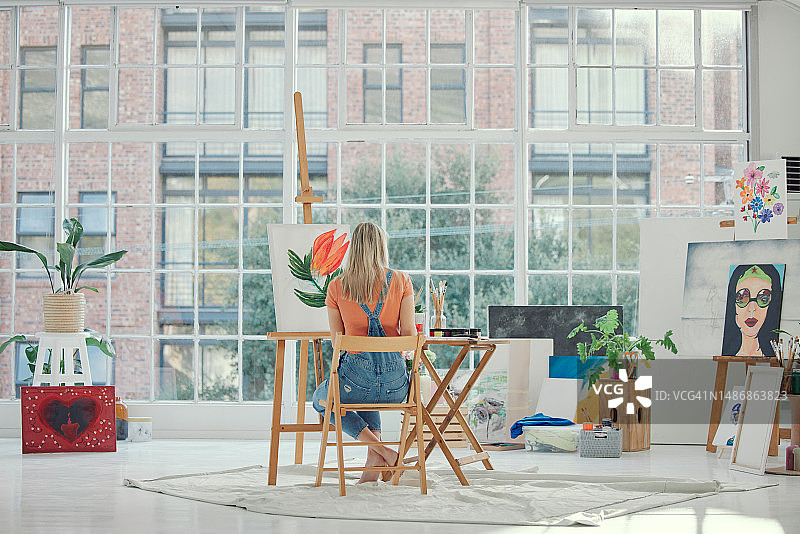 在画室或工作室用画架和油画颜料在画布上绘画的女人图片素材