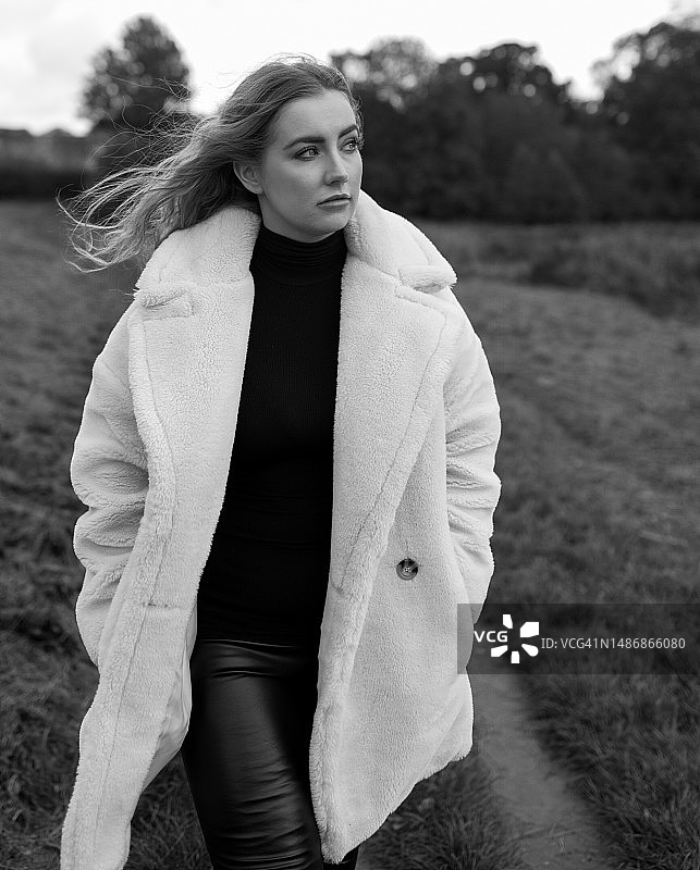 年轻女子站在田野上，英国，凯尼尔沃思图片素材