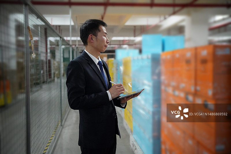 工厂经理在仓库中使用平板电脑图片素材