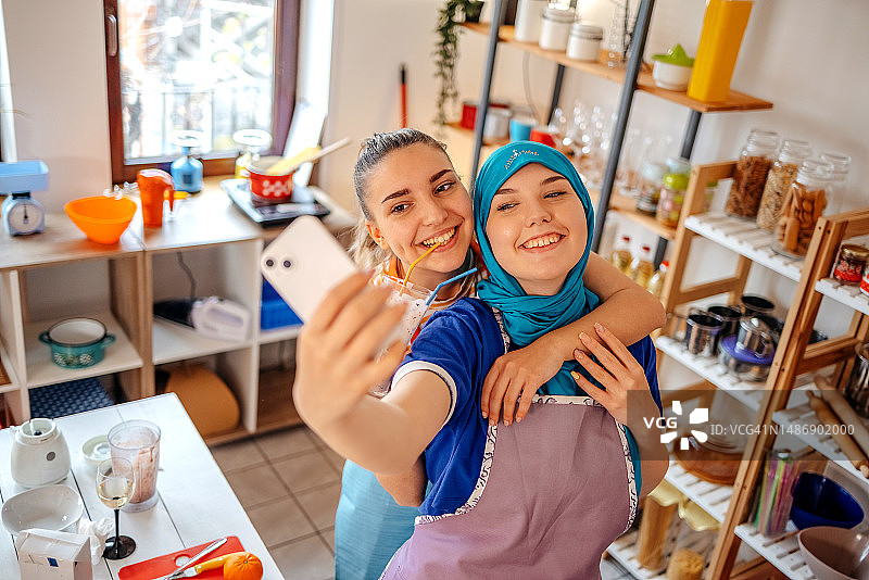 两名年轻女子在家准备健康餐和饮料，自拍图片素材